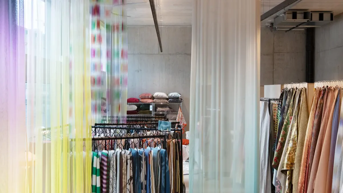 Showroom von ZigZagZürich mit farbigen Vorhängen und Stoffmusterständern