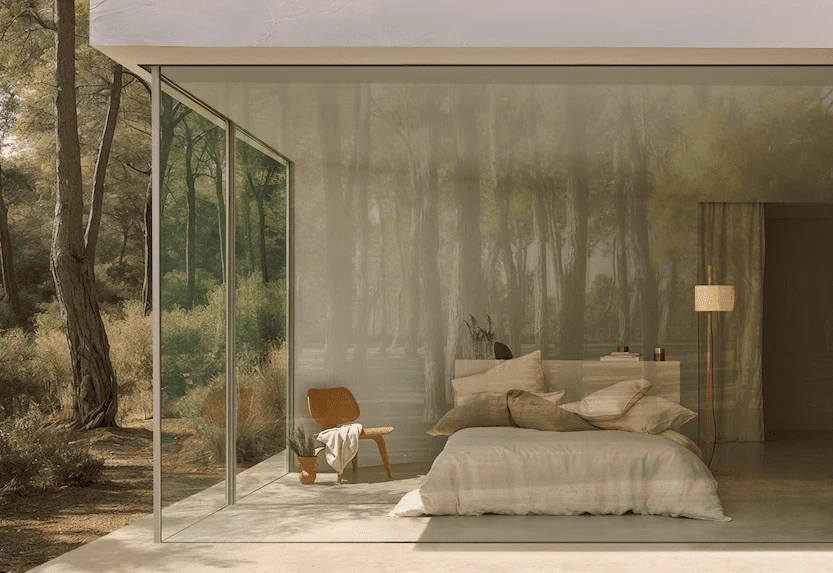 Schlafzimmer mit bodentiefer Glasfront und Blick in einen Pinienwald, Bett in ruhigen Naturtönen